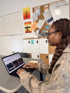Student searching academic databases on laptop with research articles visible