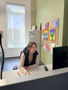 Student writing and editing a research proposal on a computer with notes around